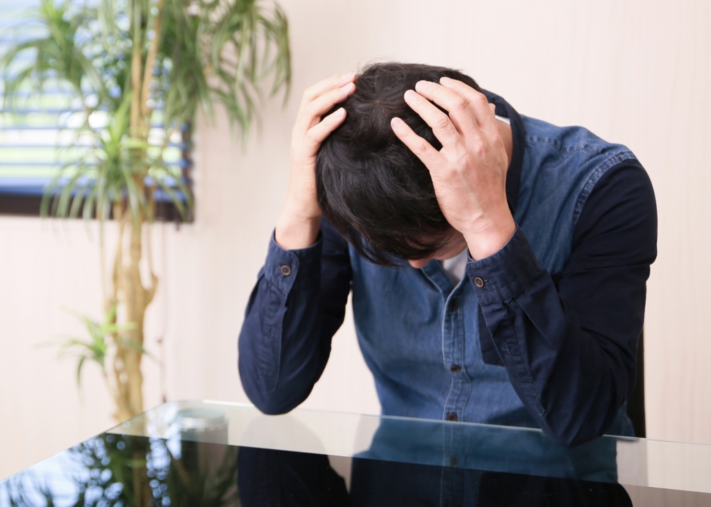 頭を抱えた男性